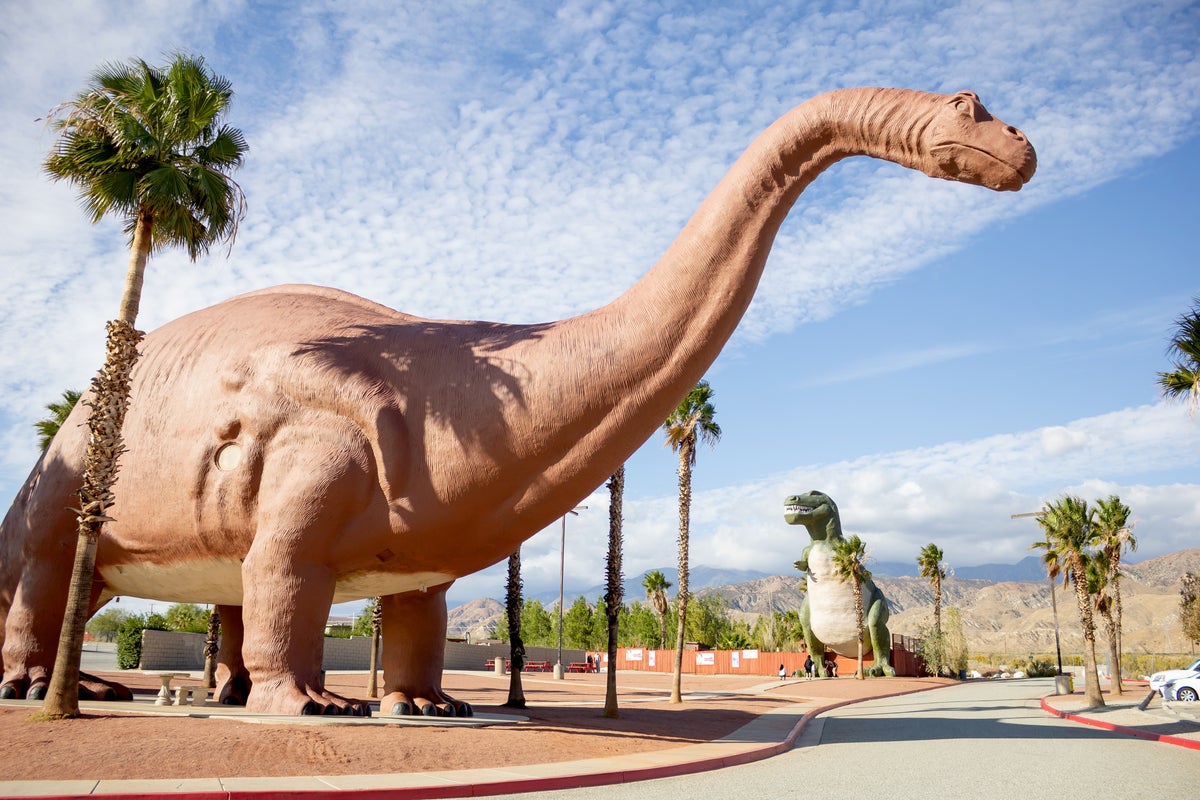 shutterstock 1591493512 dinosaur roadside attraction brontosaurus T Rex clouds blue sky